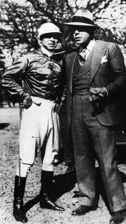 Portrait or photograph of Carlos Gardel: Jockey uruguayo Ireneo Leguisamo junto a Carlos Gardel en el Hipódromo de Palermo (Buenos Aires)