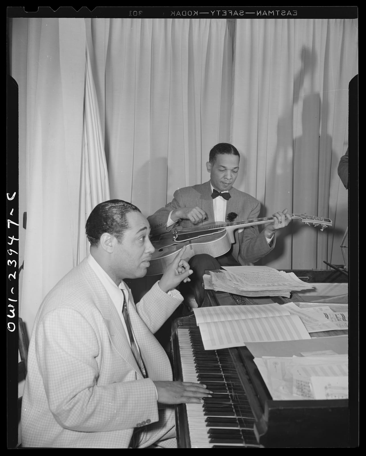 Portrait or photograph of Duke Ellington: Duke Ellington directing his band from the piano at the Hurricane cabaret
