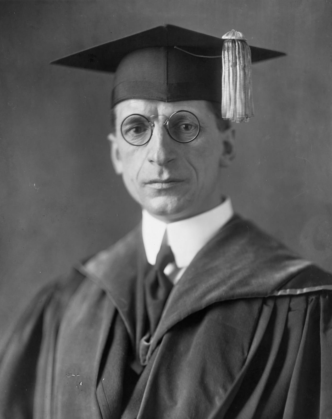 Portrait or photograph of Eamon de Valera: Title: Eamon De Valera, head-and-shoulders portrait, facing front, wearing cap and gown Abstract/medium: 1 photograph