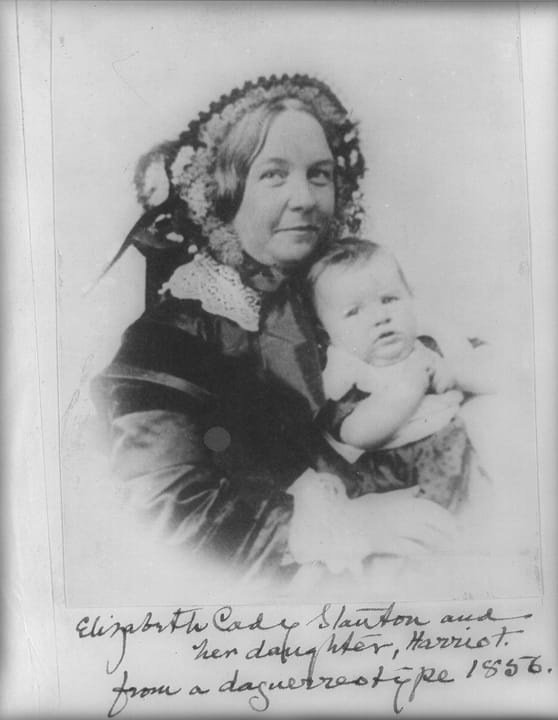 Portrait or photograph of Elizabeth Cady Stanton: Elizabeth Cady Stanton holding her daughter Harriot, half-length portrait, facing right. (cropped)