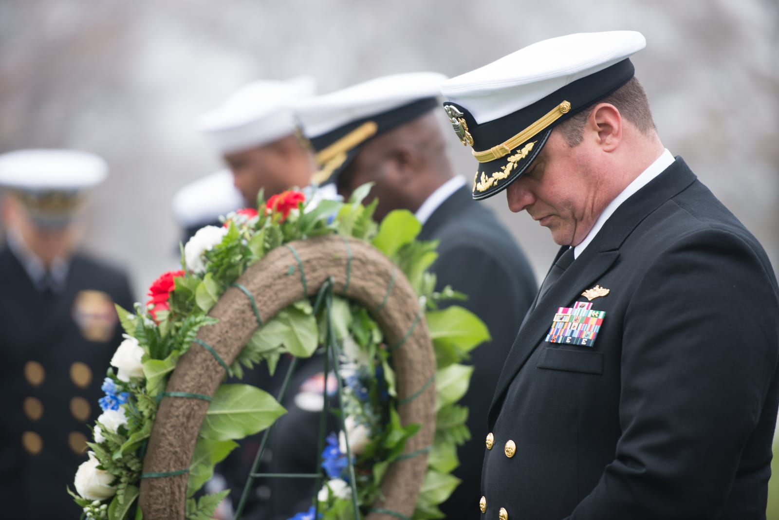 Portrait or photograph of Grace Hopper: Cmdr Joseph Fraser bows his head during a ceremony to honor U.S. Navy Rear Admiral Grace Hopper at Arlington National Ce