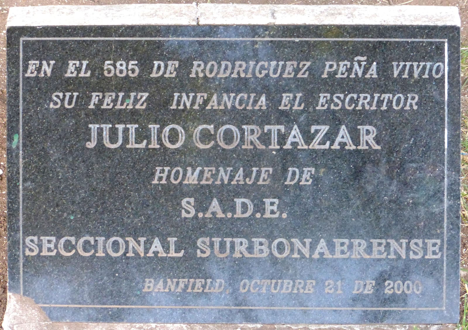 Portrait or photograph of Julio Cortazar: Placa en conmemoración a Julio Cortázar en la Plaza Alfredo De Angelis de Banfield, Argentina.