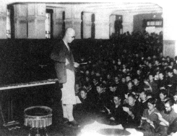 Portrait or photograph of Kosaku Yamada: 明治大学で応援歌の指揮を執る山田耕筰(1930年)
