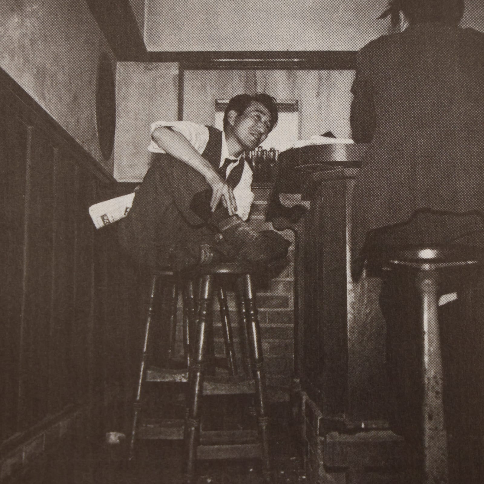Portrait or photograph of Osamu Dazai: 銀座のバールパンで撮影された太宰治。右には坂口安吾の後ろ姿。
