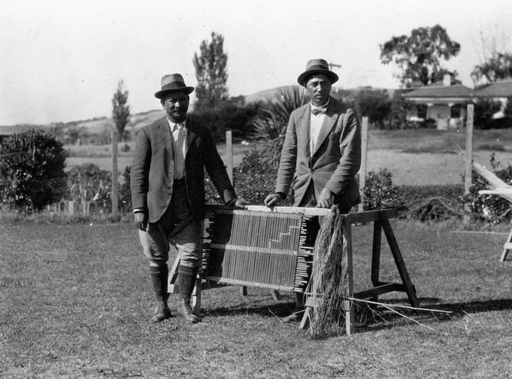 Portrait or photograph of Peter Buck: Apirana Ngata and Peter Buck alongside a tukutuku panel at Ngata's home at Waiomatatini, during a Dominion Museum expediti