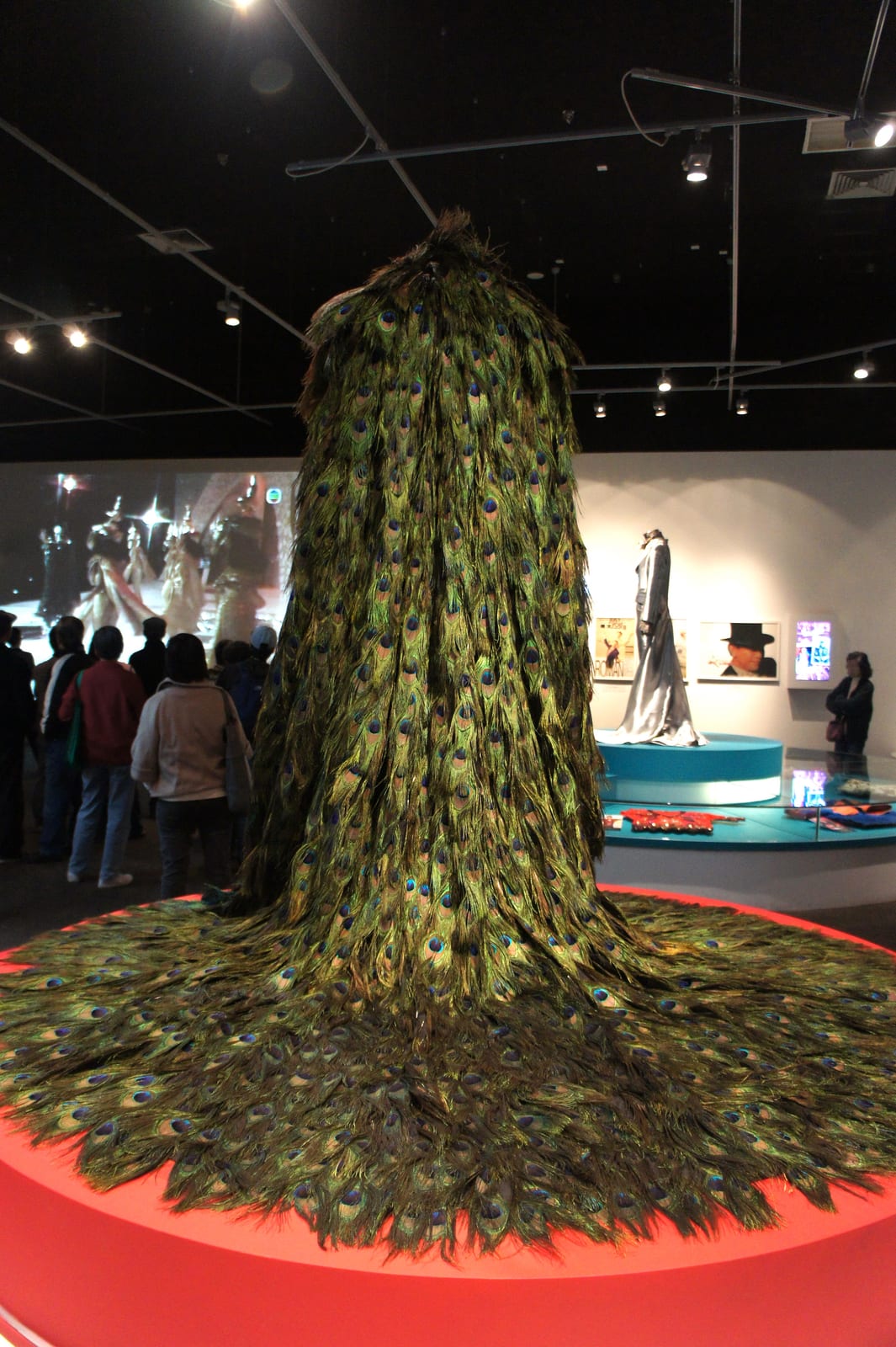Portrait or photograph of Roman Tam: HKHM - Applauding to Hong Kong Pop Legend - Roman Tam peacock feathers costume. Roman Tam wore this costume with peacock fe