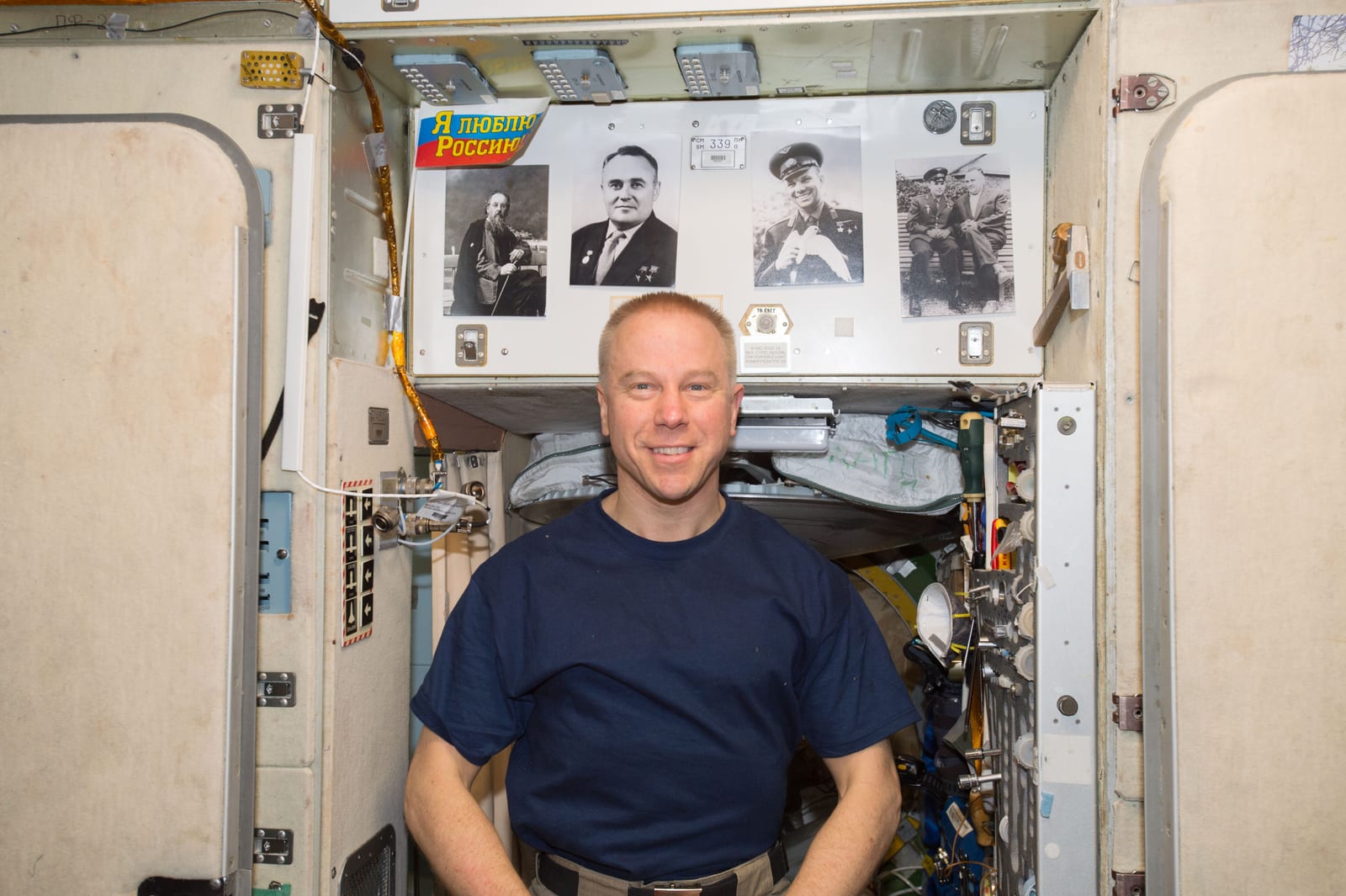 Portrait or photograph of Sergei Korolev: NASA astronaut Tim Kopra, Commander of Expedition 47, floats inside the Russian segment on Cosmonautics Day 2016. Behi