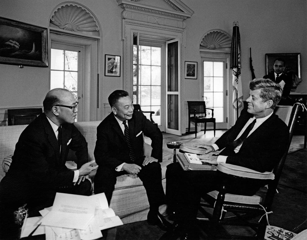 Image connected to Shen Kuo: President John F. Kennedy (in rocking chair at right, holding books in his lap) meets with Deputy Secretary General of the National