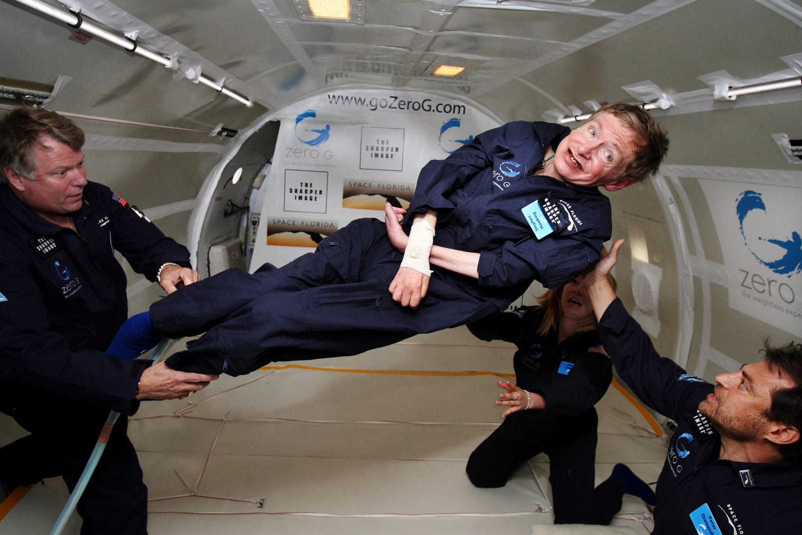 Portrait or photograph of Stephen Hawking: Noted physicist Stephen Hawking (center) enjoys zero gravity during a flight aboard a modified Boeing 727 aircraft ow