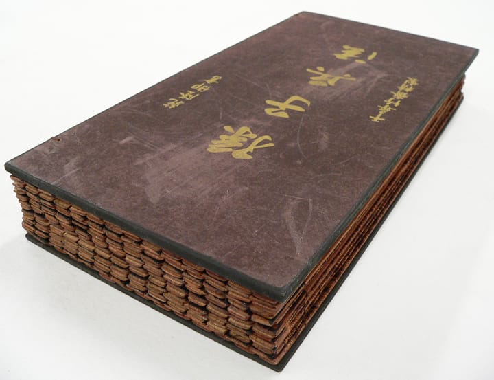 Portrait or photograph of Sun Tzu: A Chinese bamboo book, closed to display the cover. This copy of The Art of War (on the cover, "孫子兵法") by Sun Tzu is part of