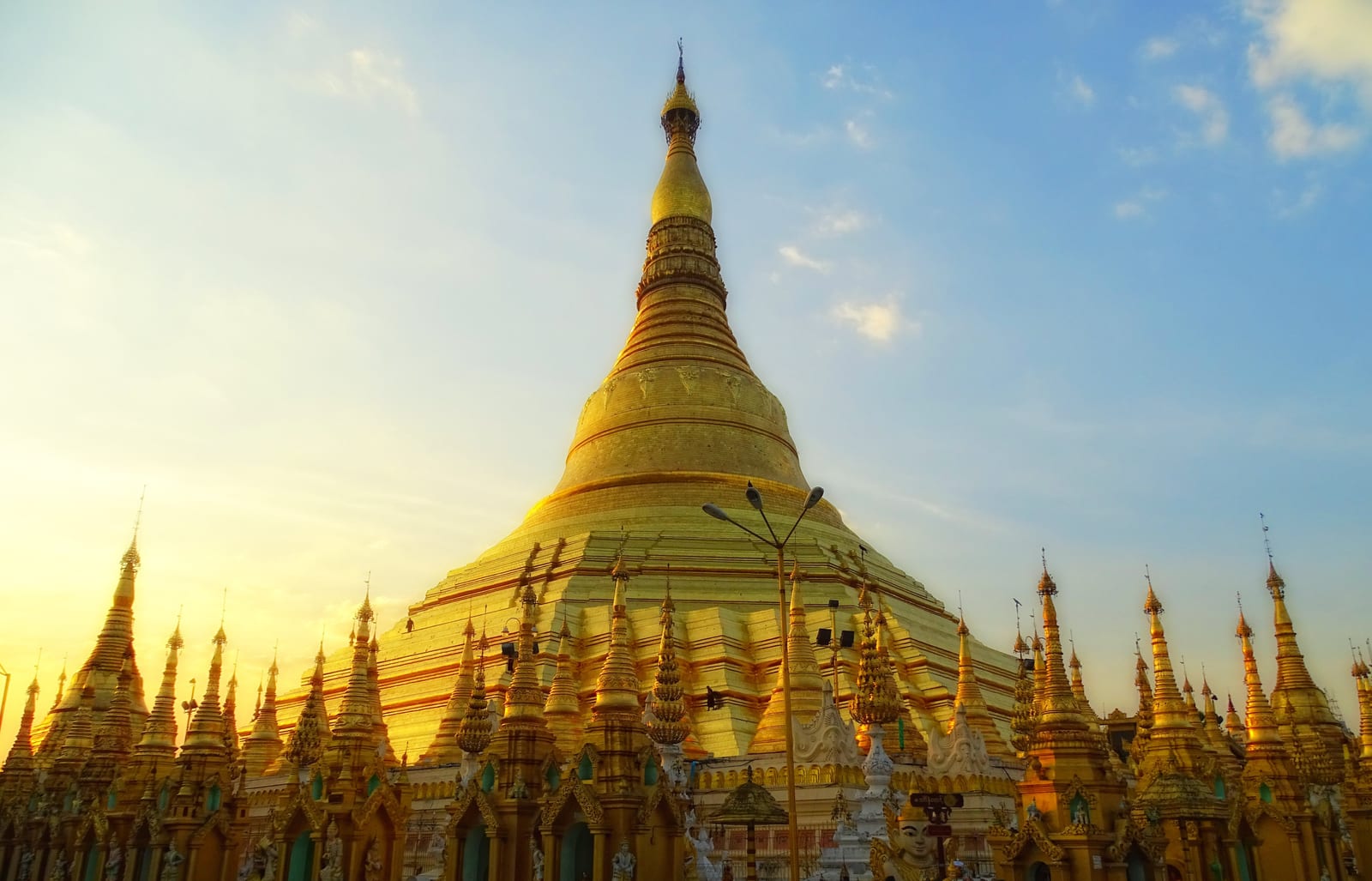 Image connected to Thakin Kodaw Hmaing: The south-eastern side of Shwedagon Pagoda. A monk is walking on the facade, demonstrating the large scale of the stupa.