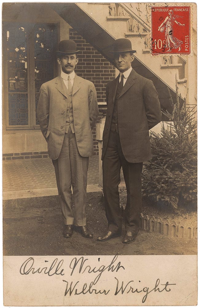 Portrait or photograph of Wilbur Wright: Real photo postcard of the Wright brothers standing side by side