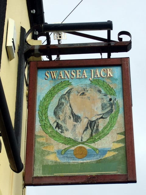 Photograph or image of Swansea Jack: Swansea Jack pub sign This heroic dog is a Swansea legend, a black retriever who in the 1930s saved the lives of, reputedly